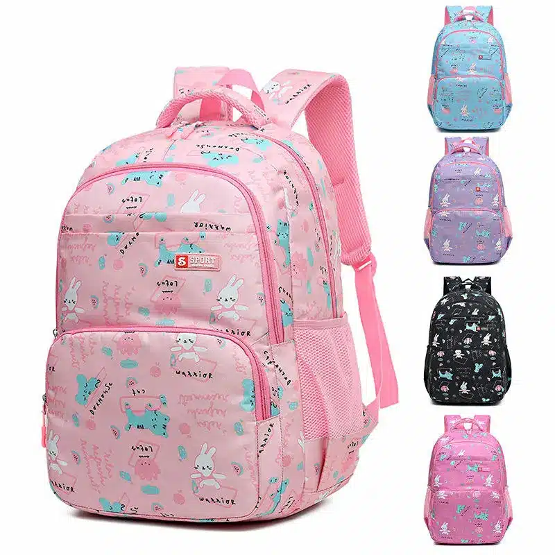 Mochilas Escolares Personalizadas 2027 4 Cuatro mochilas escolares en rosa, azul, morado y negro, con estampados de conejitos y dinosaurios, bolsillos delanteros y laterales, y asas en la parte superior.